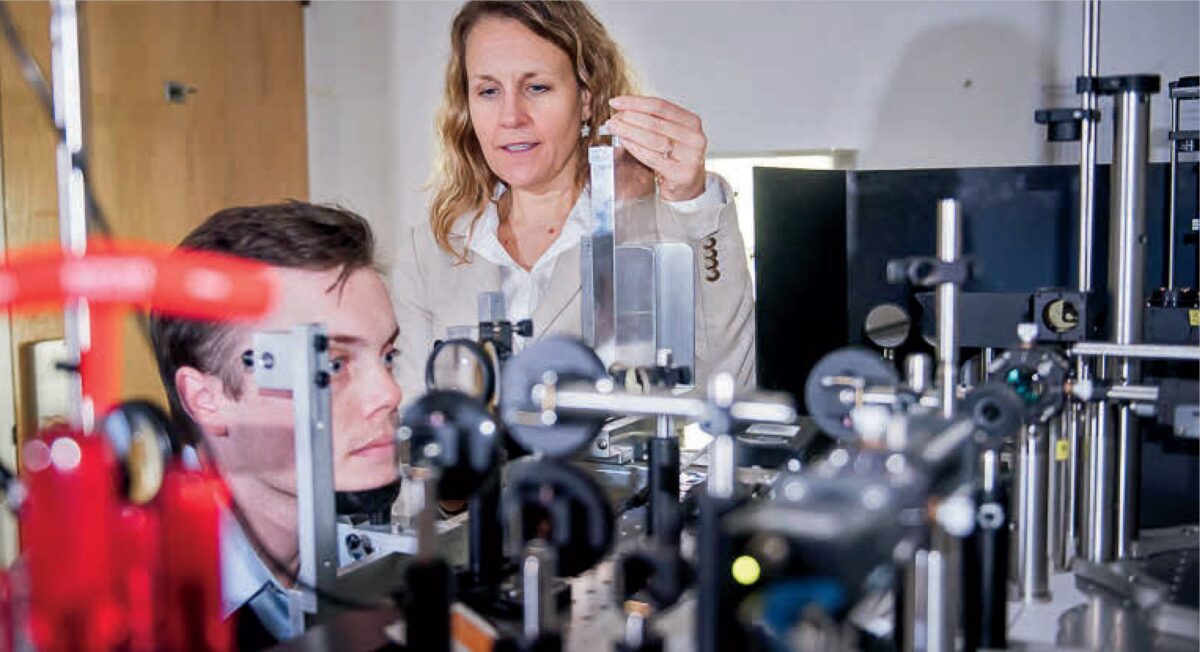 One woman and one man working with scientific equipment in a laboratory.