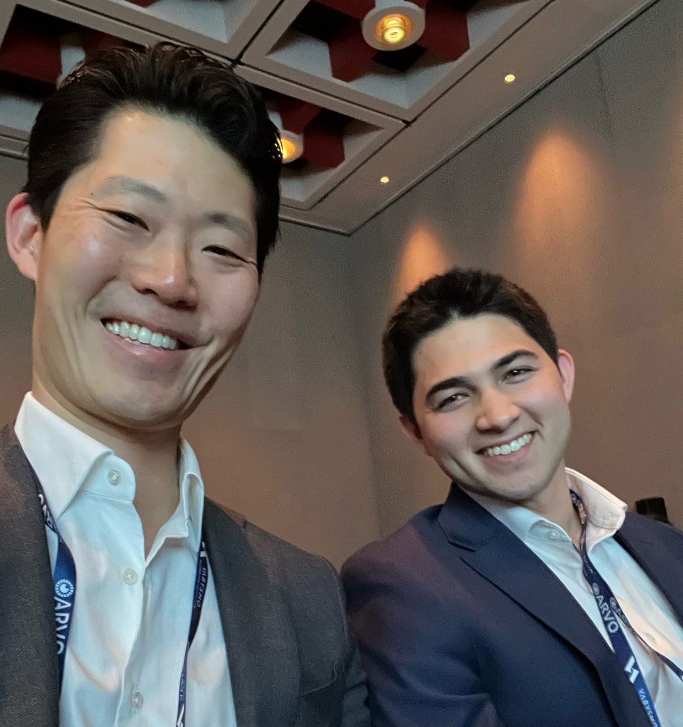 Two men smiling in business attire.