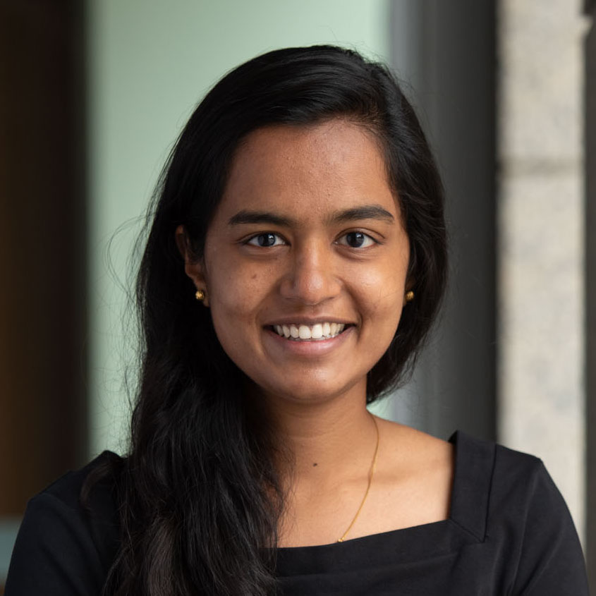 A young woman smiling in a professional setting.