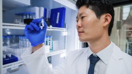 Scientist examining a vial in laboratory.