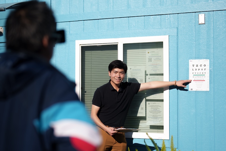 Young man pointing at eye chart.