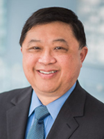 Smiling man in suit with blue tie.