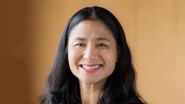 Smiling woman with long black hair.