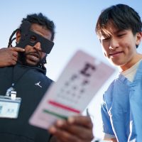 A medical worker giving a patient an eye exam.